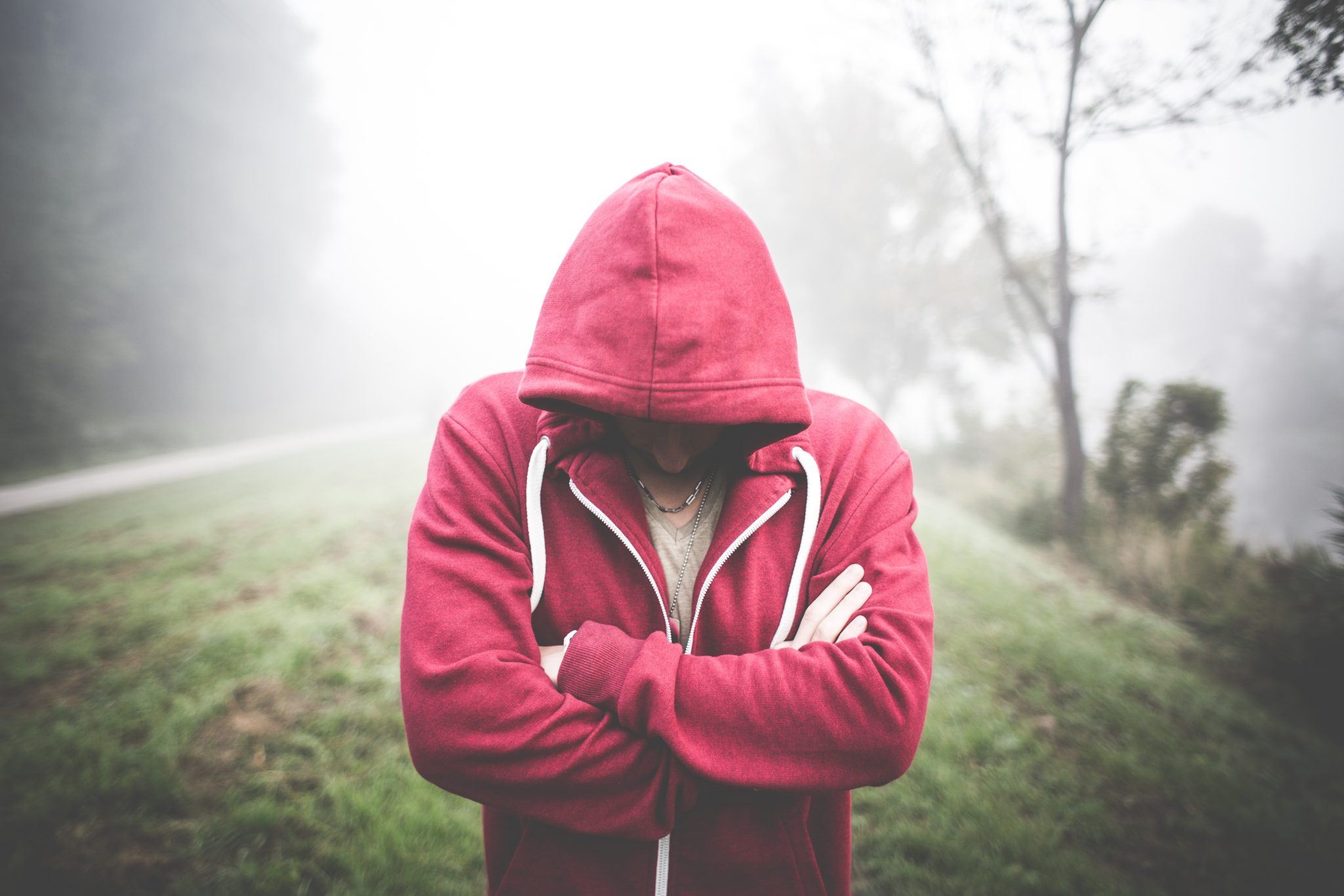 A fight, a nose bite, and $110,000 later: A (Legal) Lesson in Keeping Your Cool A man in a red hoodie standing in a foggy field experiencing bankruptcy.